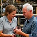 Expert angler assisting a customer with fishing gear in a well-lit fishing shop